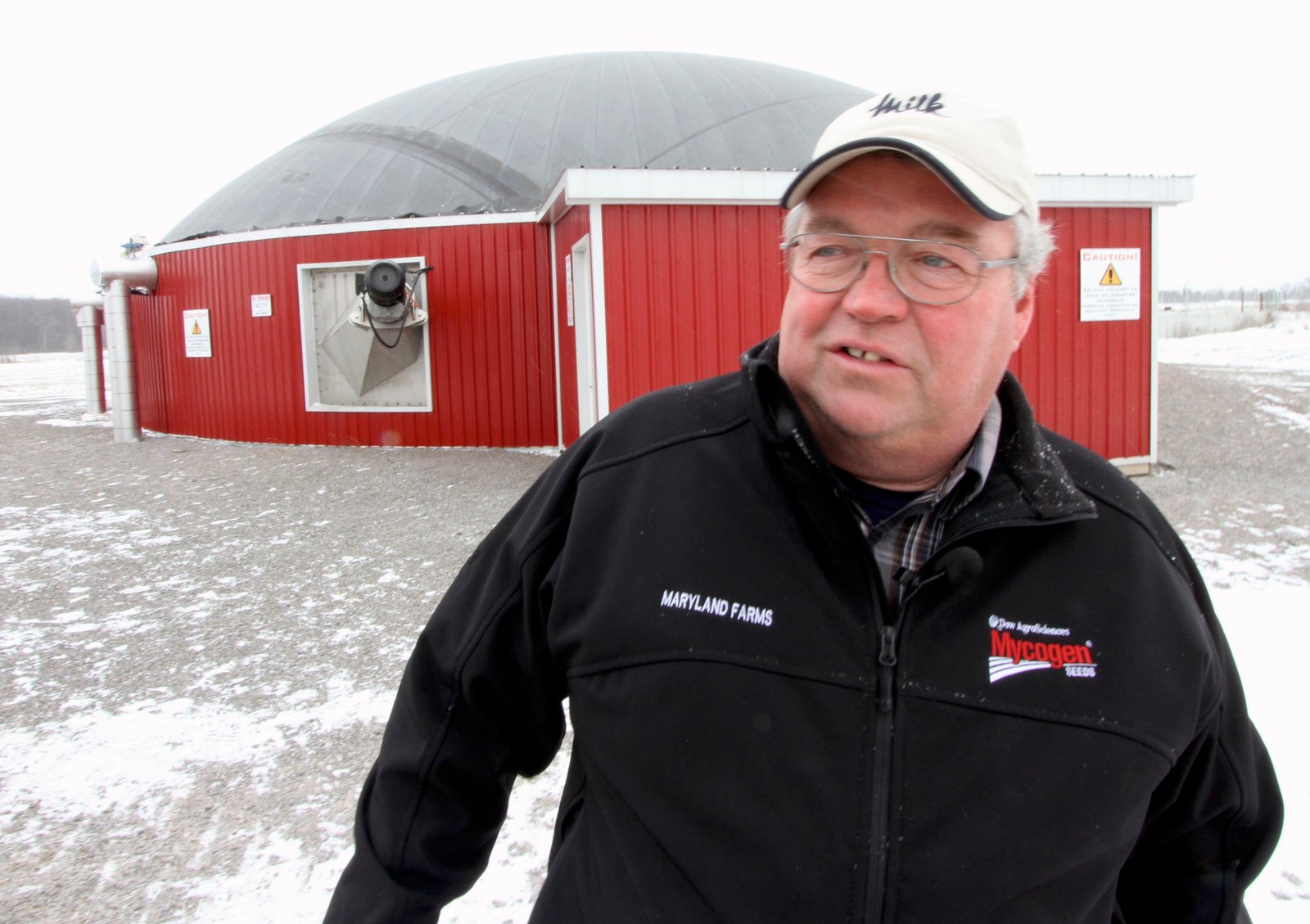 James Callaghan and his two brothers run Maryland Farms, a 250 cow dairy operation that set up a biogas operation on their site two years ago. Behind him is the anaerobic digester.