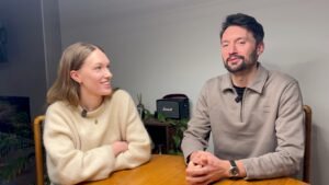 a man and woman sitting at a table - carbon neutral community