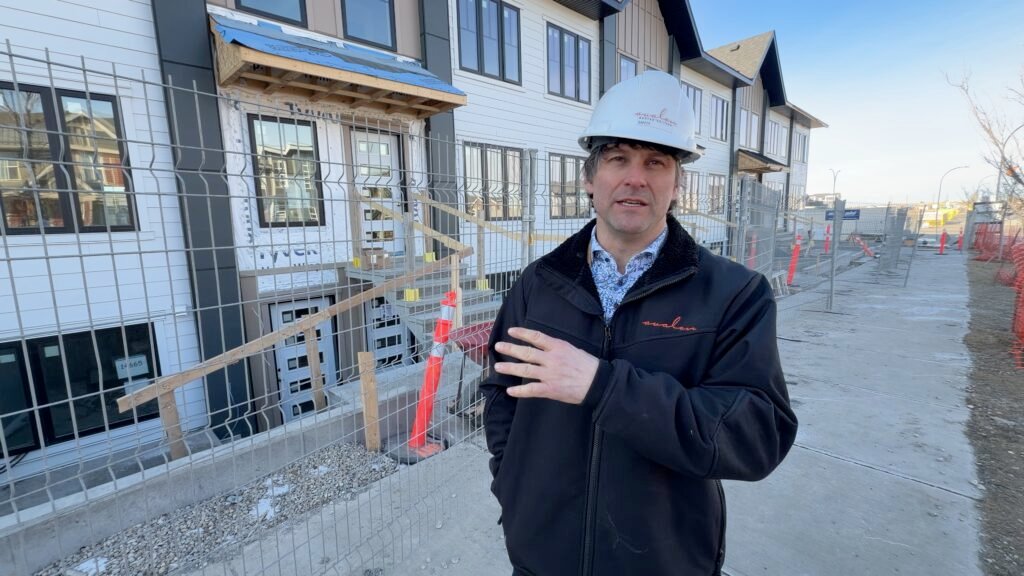 Chris Williams with fencing and homes in background